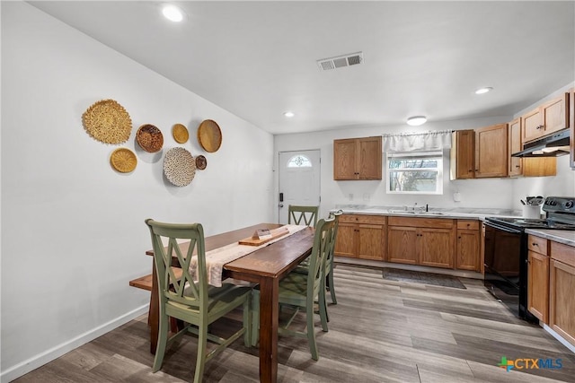 interior space with black range with electric cooktop, hardwood / wood-style flooring, and sink