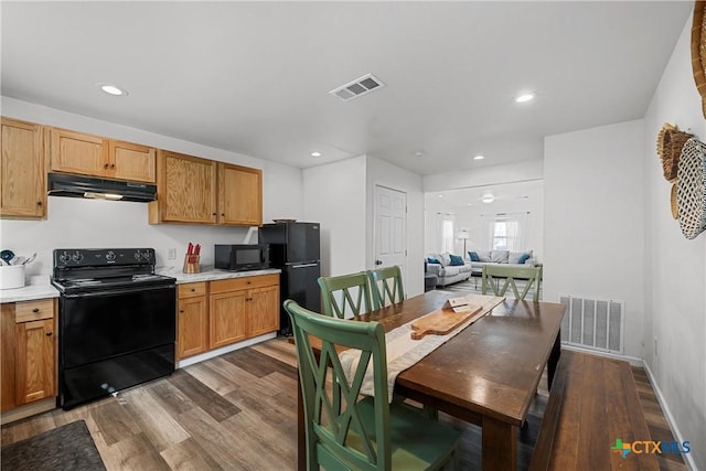 kitchen with hardwood / wood-style flooring and black appliances