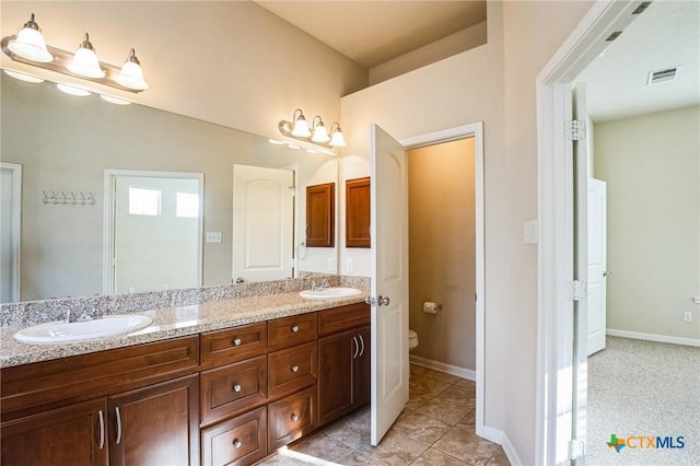 bathroom with vanity, toilet, and tile patterned flooring