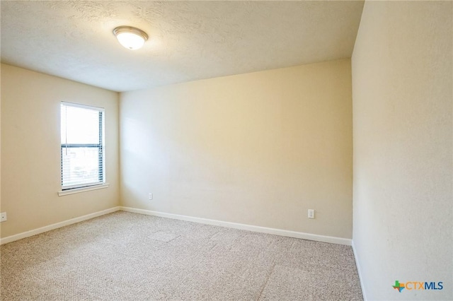 carpeted spare room with a textured ceiling