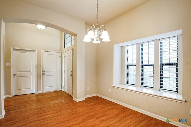 spare room featuring hardwood / wood-style floors and a notable chandelier