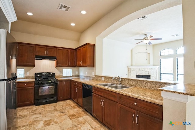 kitchen with sink, black appliances, kitchen peninsula, and light stone countertops