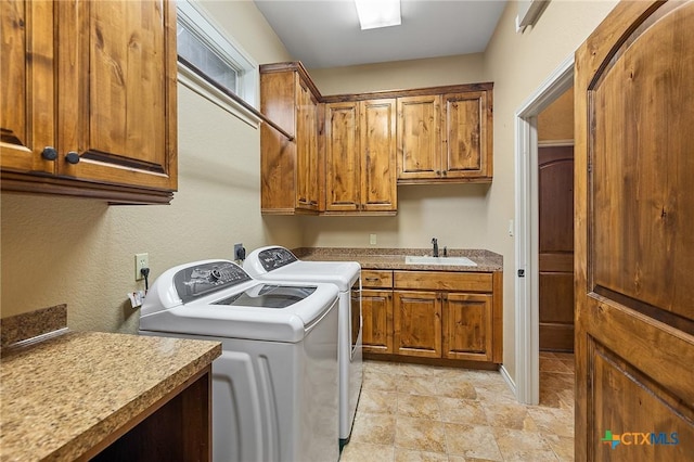 washroom featuring cabinets, washer and clothes dryer, and sink