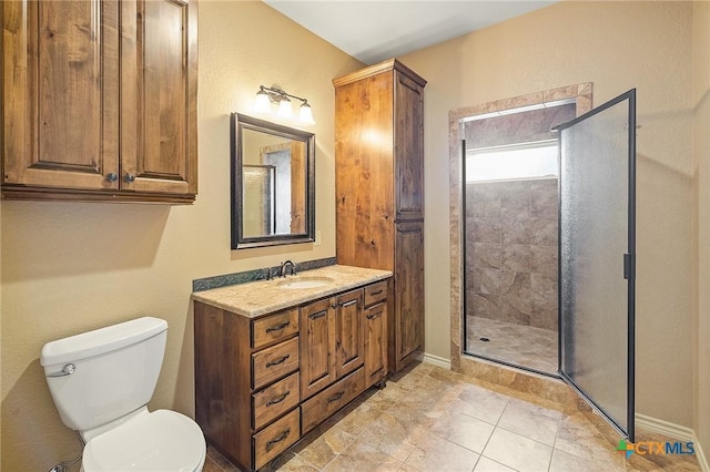 bathroom with a shower with shower door, toilet, and vanity