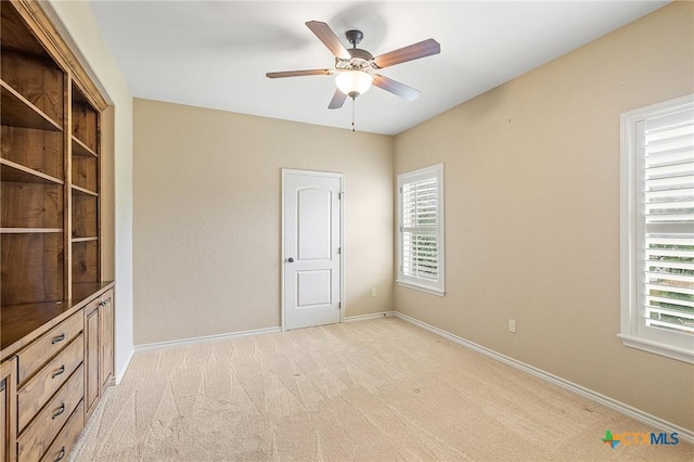 carpeted spare room featuring ceiling fan