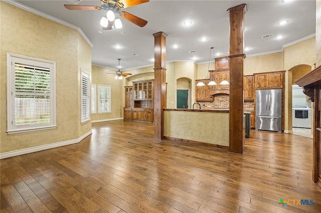 kitchen with ornate columns, stove, dark hardwood / wood-style flooring, hanging light fixtures, and stainless steel refrigerator