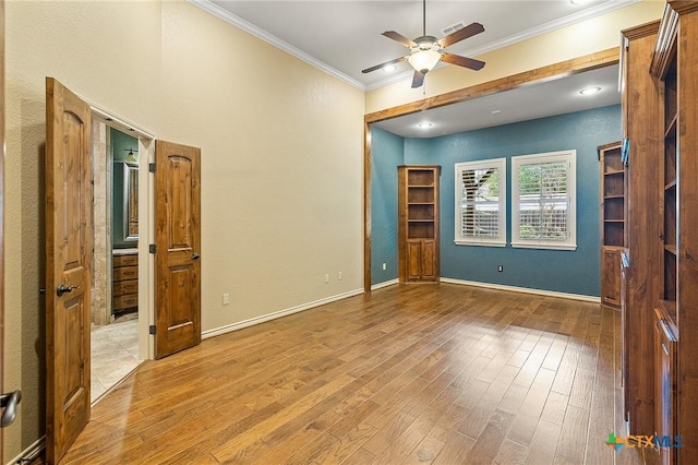 unfurnished bedroom with ceiling fan, crown molding, and light wood-type flooring