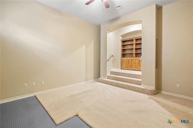 empty room featuring ceiling fan, carpet, and built in features