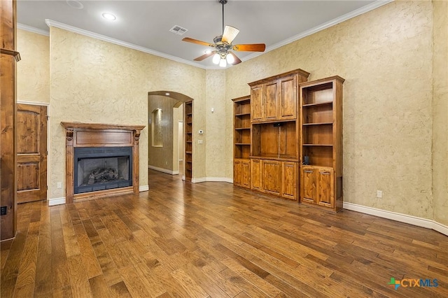 unfurnished living room featuring ceiling fan, dark wood-type flooring, and crown molding