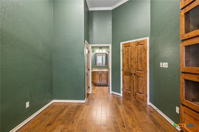 hallway with wood-type flooring and crown molding