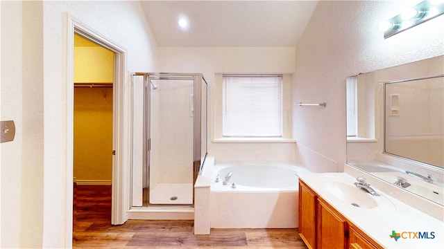 bathroom with vanity, shower with separate bathtub, hardwood / wood-style floors, and vaulted ceiling