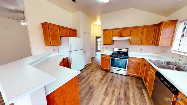 kitchen featuring stainless steel appliances, sink, kitchen peninsula, lofted ceiling, and light hardwood / wood-style flooring