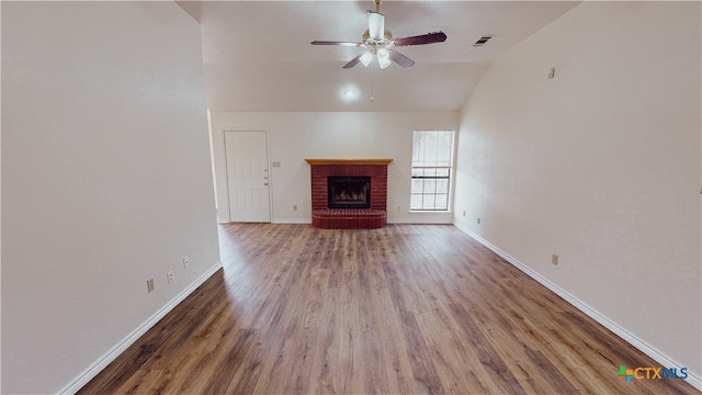 unfurnished living room with a fireplace, dark hardwood / wood-style floors, ceiling fan, and vaulted ceiling