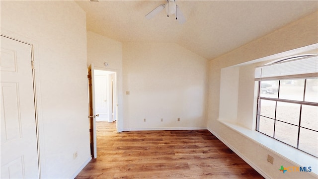 empty room featuring light hardwood / wood-style floors, ceiling fan, and lofted ceiling