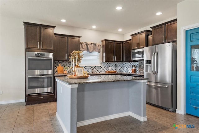 2014 Deer Field Way, Harker Heights, TX 76548 - kitchen with appliances with stainless steel finishes, dark stone counters, dark brown cabinetry, a center island, and backsplash