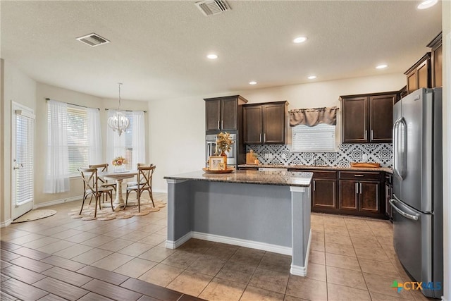 2014 Deer Field Way, Harker Heights, TX 76548 - kitchen with stainless steel appliances, dark stone countertops, backsplash, dark brown cabinetry, and a textured ceiling