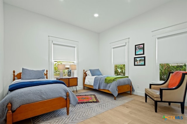 bedroom featuring multiple windows and light hardwood / wood-style flooring