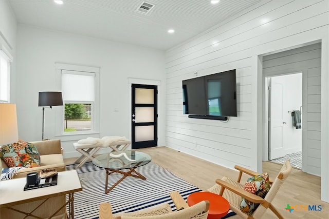 living room featuring wooden walls and light wood-type flooring