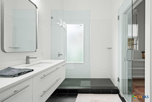 bathroom with vanity, a shower with shower door, and tile patterned flooring