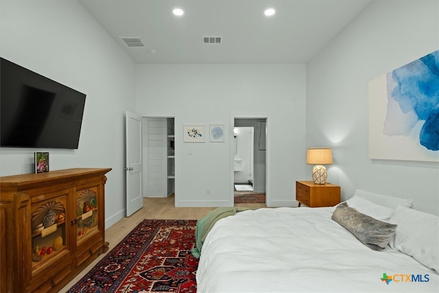 bedroom featuring ensuite bathroom and light hardwood / wood-style floors