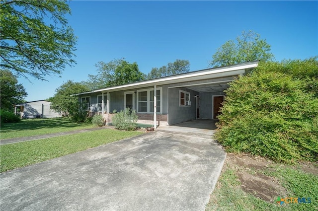 single story home featuring driveway, a front yard, and an attached carport