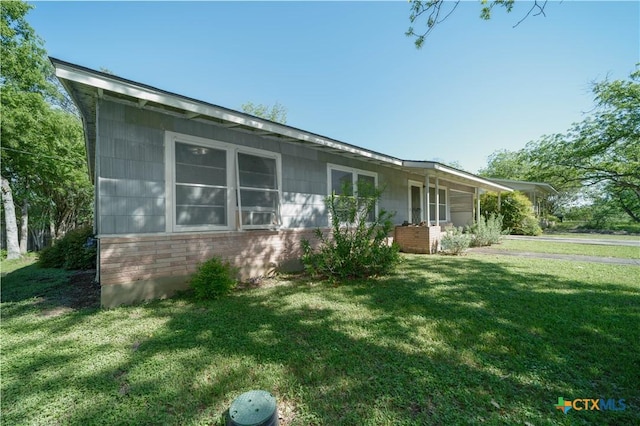 view of side of home with a yard and brick siding