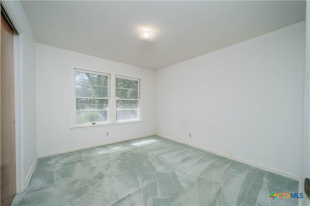 carpeted empty room with baseboards