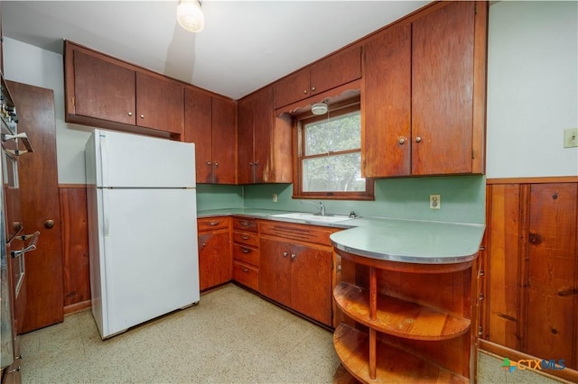 kitchen with freestanding refrigerator, light floors, a sink, open shelves, and light countertops