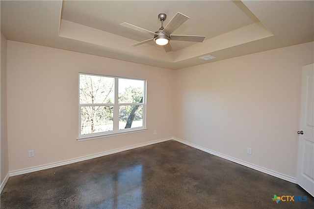 spare room featuring ceiling fan and a tray ceiling