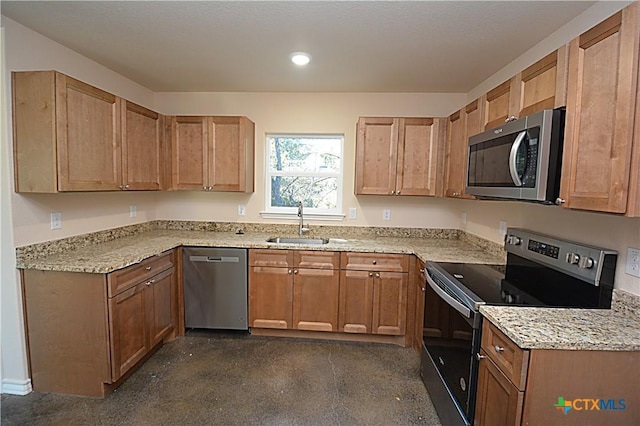 kitchen with light stone countertops, stainless steel appliances, and sink