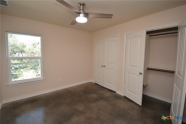 unfurnished bedroom with ceiling fan and multiple closets