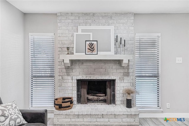 room details featuring wood-type flooring and a brick fireplace