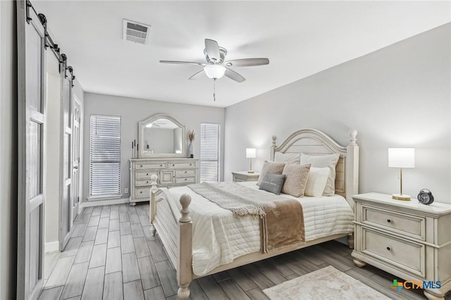 bedroom featuring ceiling fan and a barn door