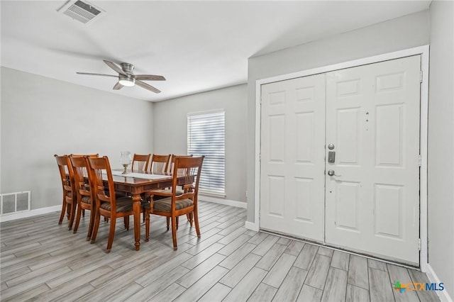 dining area with light wood-type flooring and ceiling fan