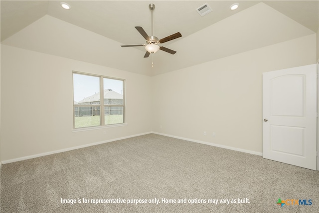 empty room with vaulted ceiling, ceiling fan, and carpet floors