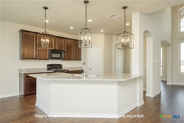 kitchen featuring black appliances, sink, an island with sink, and dark hardwood / wood-style floors