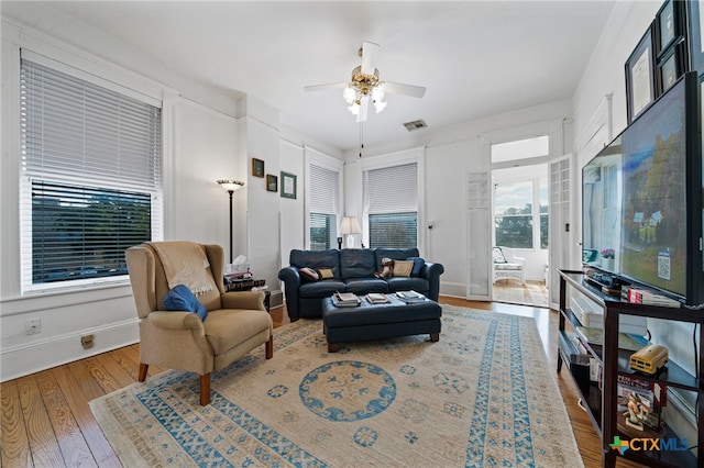 living room with wood-type flooring and ceiling fan