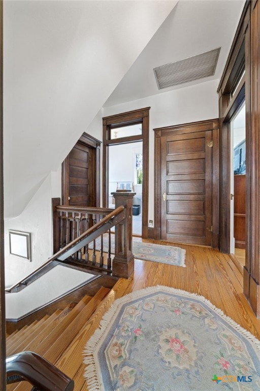 foyer with lofted ceiling, a healthy amount of sunlight, and light hardwood / wood-style flooring