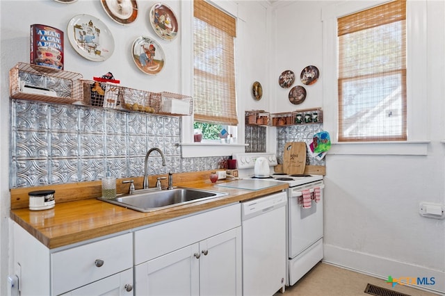 kitchen with dishwasher, white cabinetry, sink, and a healthy amount of sunlight