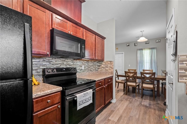 2709 Odem St, Victoria, TX 77901 - kitchen featuring black appliances, light wood-style floors, backsplash, light countertops, and decorative light fixtures