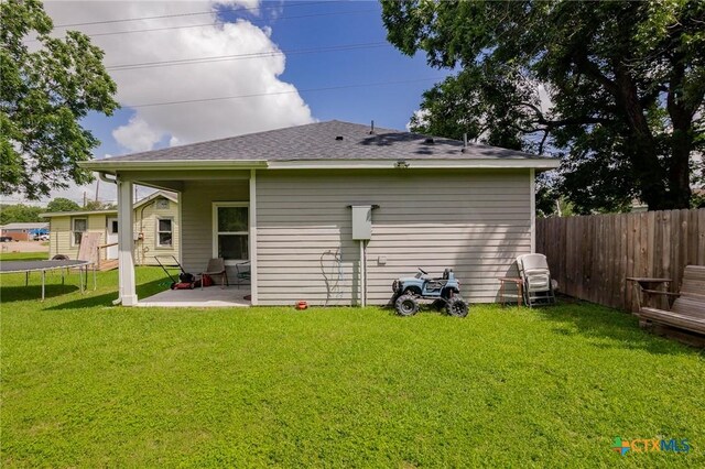 2709 Odem St, Victoria, TX 77901 - rear view of house featuring a patio, a trampoline, and roof with shingles