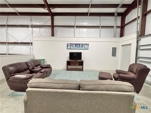 living room with a high ceiling and concrete floors