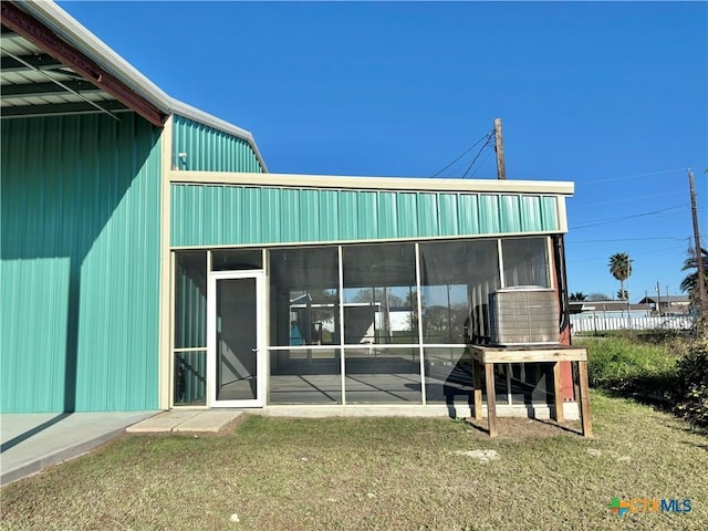 back of property featuring a sunroom and a yard