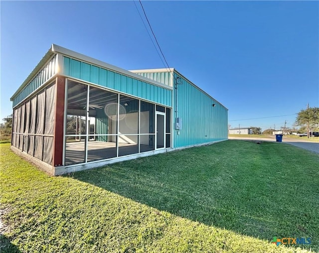 rear view of property with a sunroom and a yard