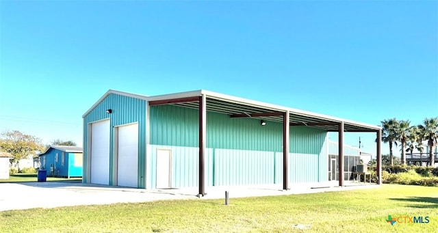 rear view of house with a yard, an outbuilding, and a garage