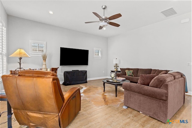 living room featuring ceiling fan and light hardwood / wood-style flooring