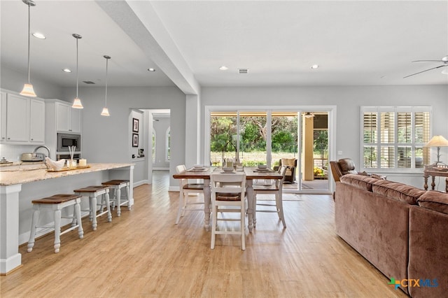 dining room with ceiling fan, plenty of natural light, and light hardwood / wood-style flooring