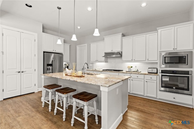 kitchen featuring white cabinetry, a center island with sink, and appliances with stainless steel finishes