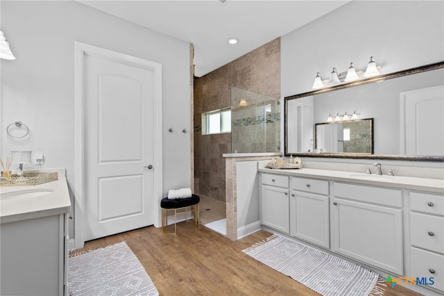 bathroom with vanity, hardwood / wood-style floors, and tiled shower