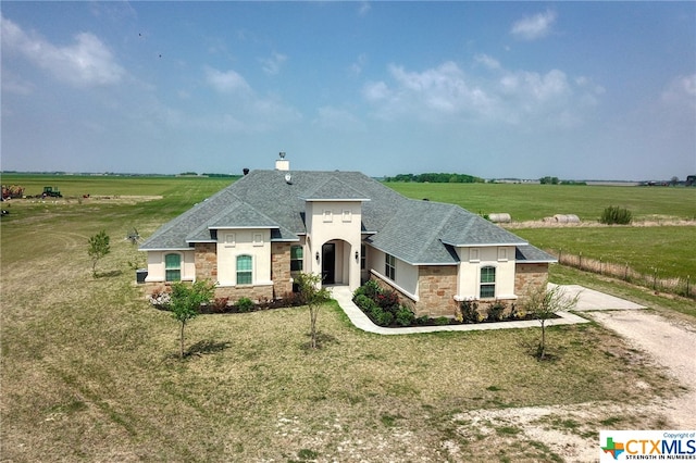 view of front of home featuring a rural view and a front lawn